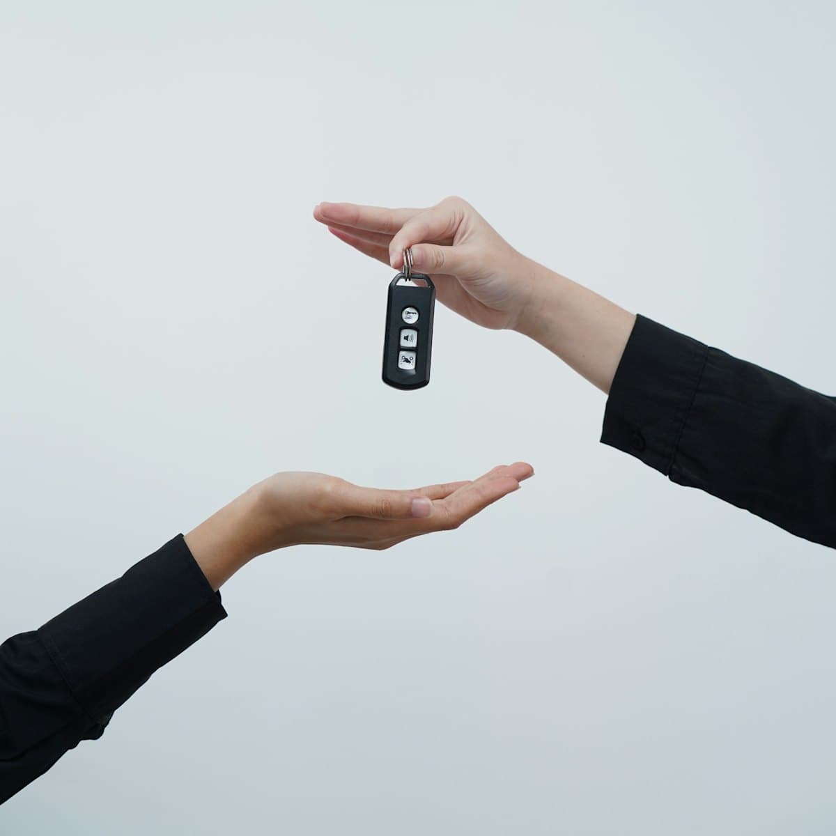 Car keys being handed from one person to another