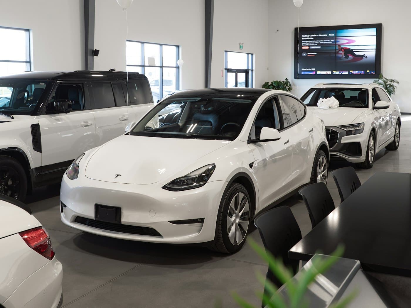 Bright dealership showroom with a white electric SUV on display