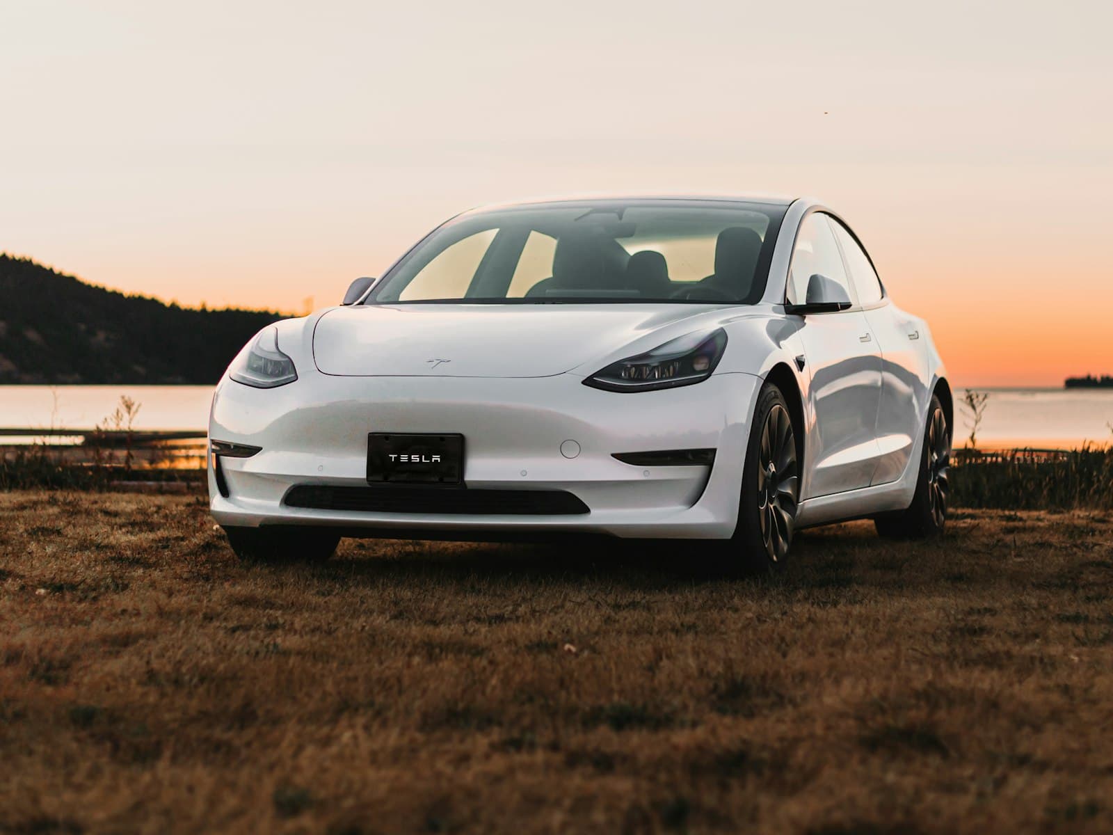 2022 Tesla Model 3 Performance in Pearl White, front three-quarter view at sunset