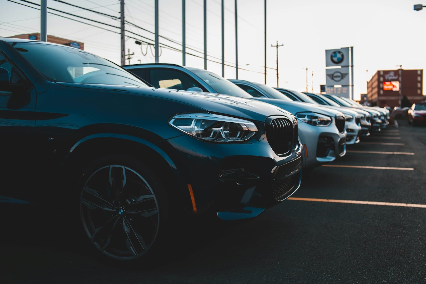 Row of vehicles on a dealership lot at sunset