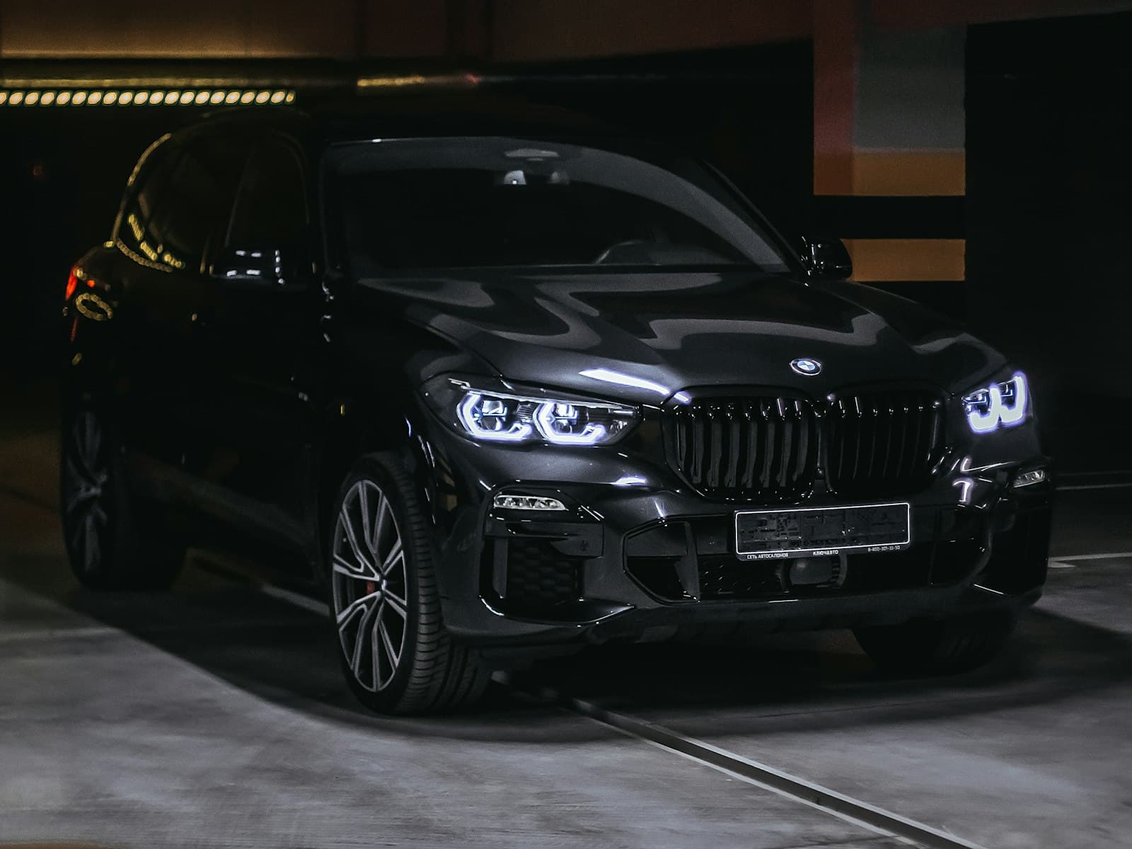 2021 BMW X5 M50i in Black Sapphire with headlights on